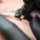 Microblading eyebrows, getting facial care and tattoo at beauty